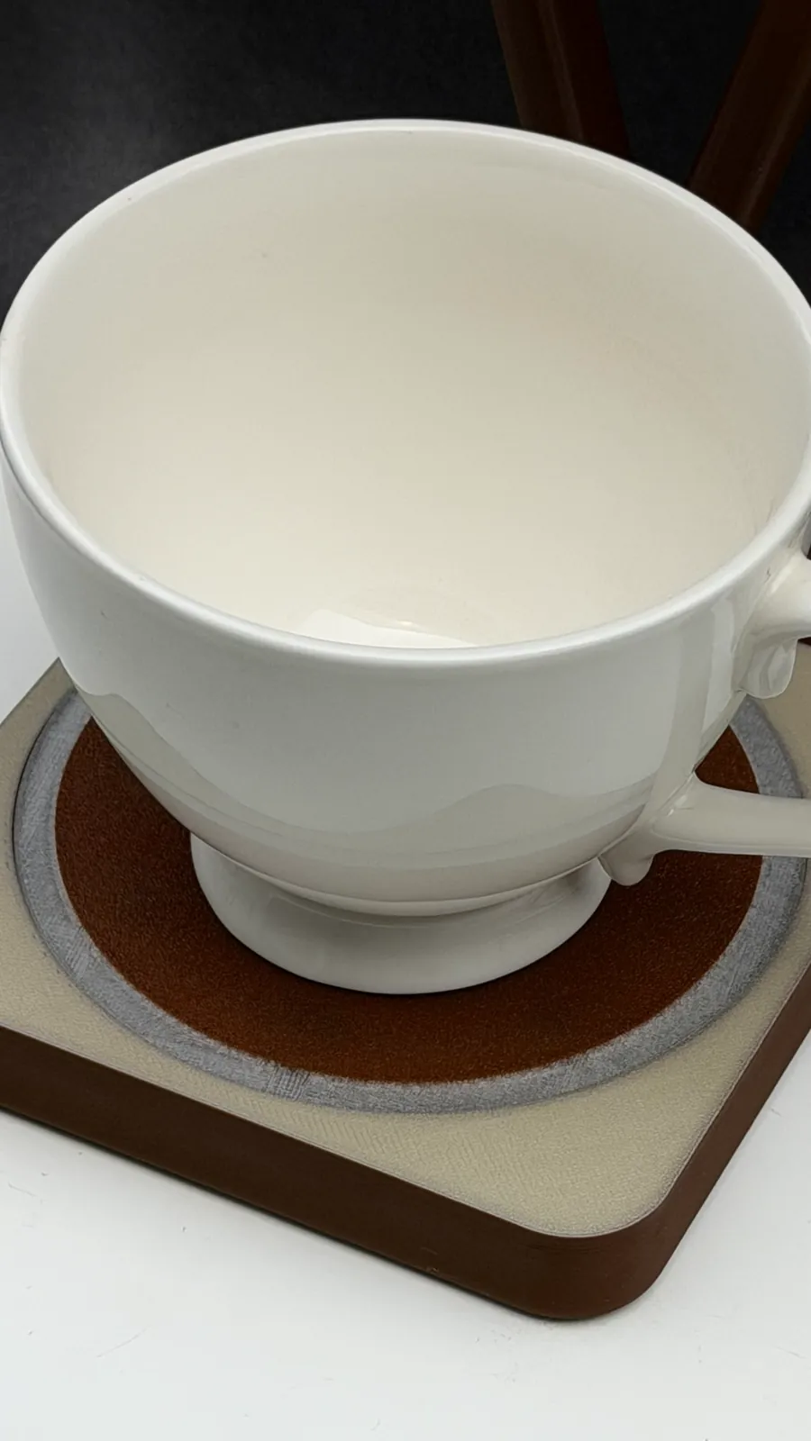A white cup sitting in the coaster