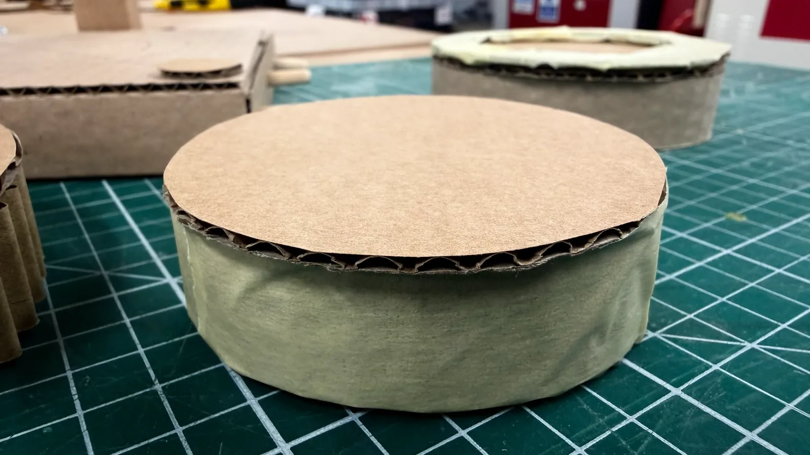 A second cardboard coaster prototype with a flat top
