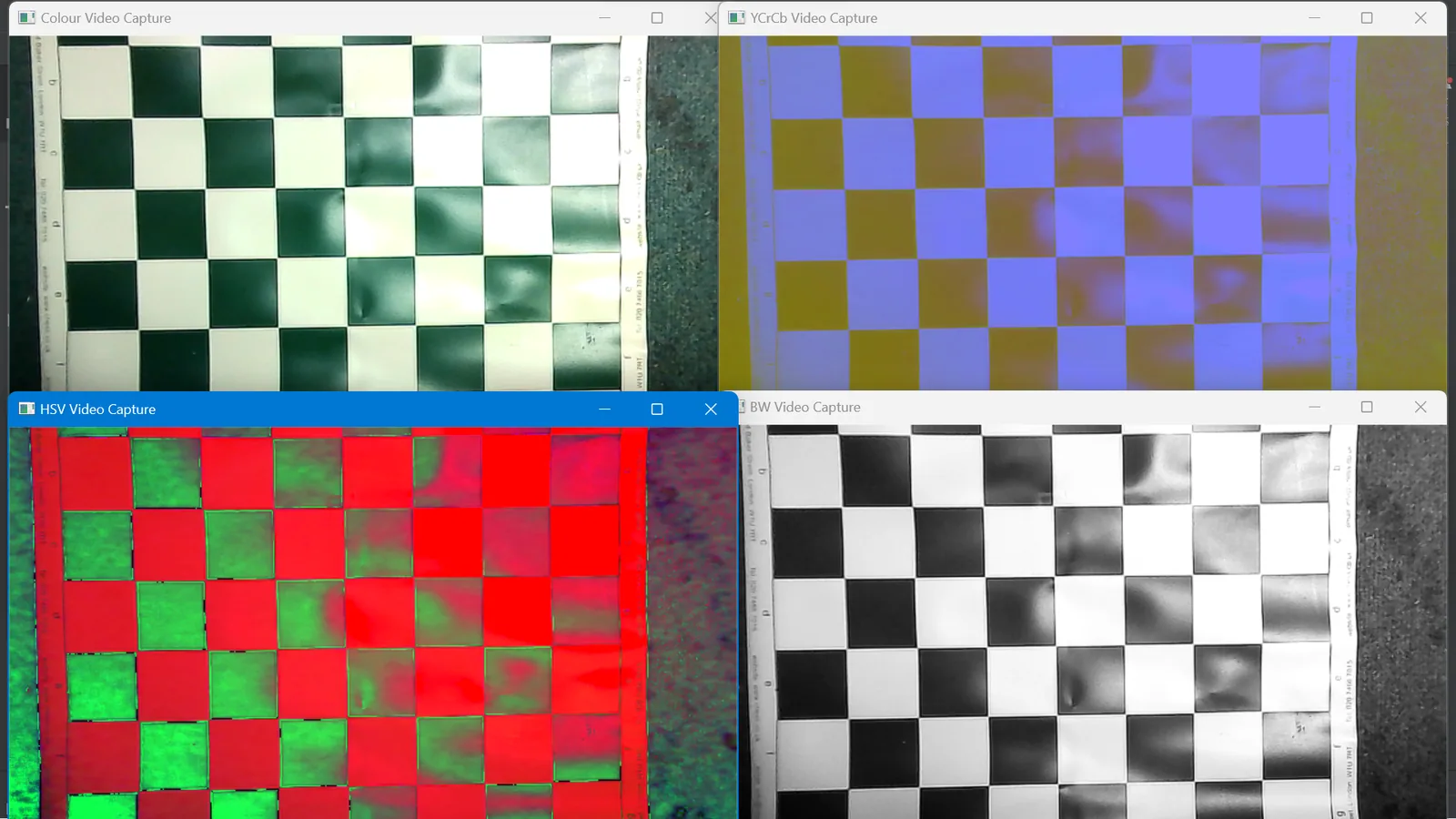 Four webcam views of the same green and white board in different colour spaces: greyscale, tinted, red and green, and high-contrast black and white