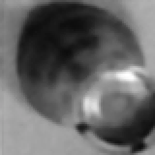A blurred greyscale close-up of one square containing a black piece seen from above