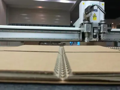 The knife cutting through fluted cardboard